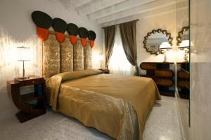 1 dormitorio con 1 cama grande y espejo en Casa Fortuny Luxury Apartment, en Venecia