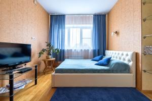 1 dormitorio con 1 cama, TV y ventana en Квартира с видом на Неву, en San Petersburgo