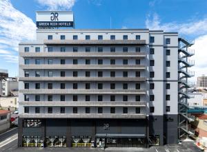 鳥取的住宿－Green Rich Hotel Tottori Ekimae (Artificial hot spring Futamata Yunohana)，白色的建筑,上面有标志