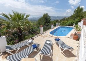 eine Terrasse mit 2 Liegestühlen und einem Pool in der Unterkunft Casabra in Palma de Gandía