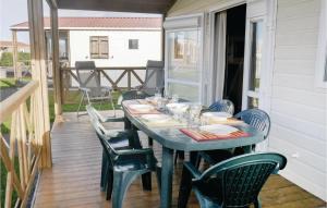 a table on the back of a porch with chairs at Nice Home In Grandcamp Maisy With Wifi in Grandcamp-Maisy