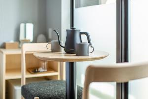 a table with two coffee mugs on top of it at HOTEL AMANEK Kyoto Kawaramachi Gojo in Kyoto