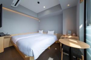 京都HOTEL AMANEK Kyoto Kawaramachi Gojo的一间有一张床和一张桌子的小房间