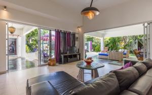 a living room with a couch and a table at Villa Purple in Legian