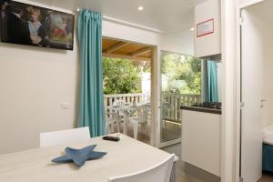 a kitchen and dining room with a table and a kitchen and a balcony at Camping Casa Di Caccia in Marina di Bibbona