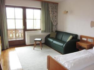 ein Hotelzimmer mit einem Sofa und einem Bett in der Unterkunft Ferienwohnungen Forellenhof Waldner in Gundersheim