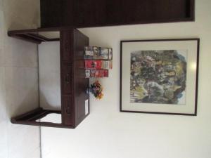 a wooden cabinet hanging on a wall with a picture at Asphodel Inn in Singapore