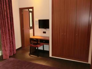 
a room with a television and a desk at Hotel California in Barcelona
