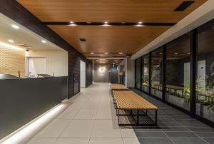 京都HOTEL AMANEK Kyoto Kawaramachi Gojo的大楼里带长凳的空走廊