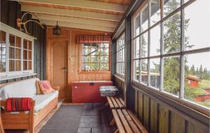 een afgeschermde veranda met een bank en ramen bij Stunning Home In Sjusjen With Kitchen in Sjusjøen