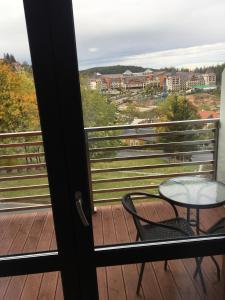 a table and chairs on a balcony with a view at Apartament Silence Triventi Agat in Karpacz