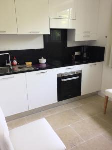 a kitchen with white cabinets and a black oven at Villa Louise-Rose in Villeneuve-Loubet
