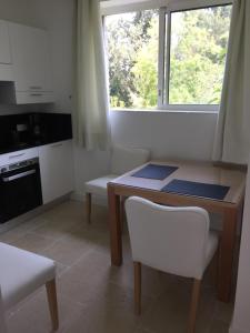 a small kitchen with a table and a window at Villa Louise-Rose in Villeneuve-Loubet