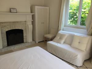 a living room with a white couch and a fireplace at Villa Louise-Rose in Villeneuve-Loubet