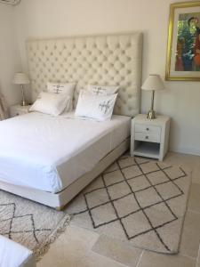 a bedroom with a large white bed and two night stands at Villa Louise-Rose in Villeneuve-Loubet