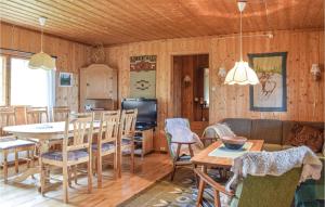een woonkamer met houten wanden en een tafel en stoelen bij Stunning Home In Sjusjen With Kitchen in Sjusjøen