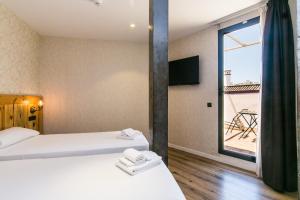 a hotel room with a bed and a television at Black Swan Hostel Sevilla in Seville