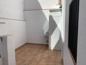 een kamer met een witte koelkast en een tegelvloer bij Casita en Granada in Granada +18 foto's