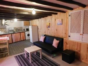 un soggiorno con un divano e un tavolo di La Casita, Apartamento Completo a Los Navalucillos