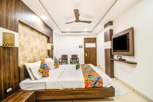 印多尔FabHotel Rajnandani Residency Bhawarkua的一间带床和平板电视的卧室