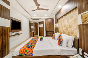 - une chambre avec un grand lit et un ventilateur de plafond dans l'établissement FabHotel Rajnandani Residency Bhawarkua, à Indore