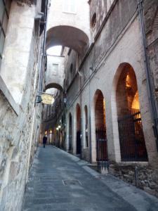 an alley in an old building with a person walking down it at Appartamento Centro Storico vicino Università in Perugia