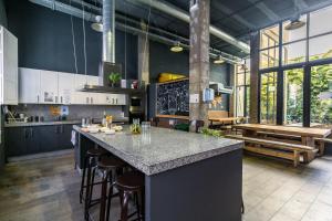 a kitchen with a large island with bar stools at Black Swan Hostel Sevilla in Seville