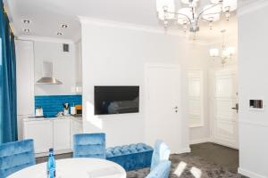 Un comedor con una mesa y sillas azules. en Apartamenty Hexus - Ofiar Oświęcimskich - Wrocław centrum Rynek, en Wroclaw