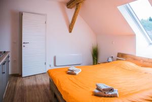 a bedroom with an orange bed with towels on it at Apartments Arh in Bohinjska Bistrica