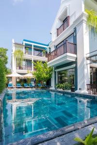 a swimming pool in front of a building at Daisy An Bang Villa in Hoi An