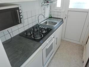a small kitchen with a stove and a sink at backpackers station in Ostend