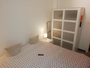 a bedroom with a bed and a cabinet with a remote on it at backpackers station in Ostend