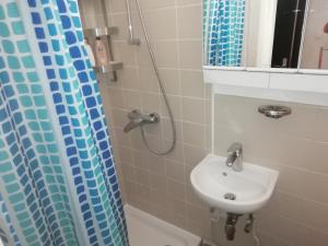 a bathroom with a sink and a shower curtain at backpackers station in Ostend