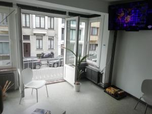 un soggiorno con una grande finestra e una sedia bianca di backpackers station a Ostenda