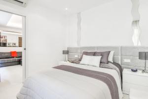 a white bedroom with a large bed and a couch at Charming 1BR Apartment In Heart Of Monaco in Monte Carlo