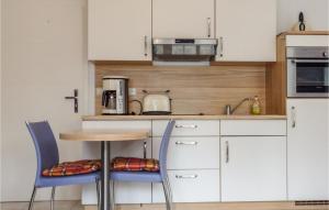ヴァーネミュンデにあるAwesome Apartment In Warnemnde With Wifiの小さなキッチン(テーブル、椅子2脚付)