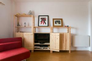 una sala de estar con TV en un centro de entretenimiento de madera en Maresia - Beachfront Peniche Apartment, en Peniche