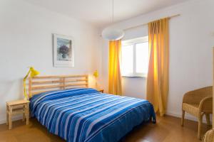 un dormitorio con una cama y una ventana en Maresia - Beachfront Peniche Apartment, en Peniche