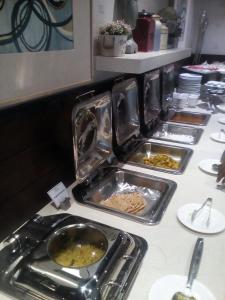 a buffet with several trays of food on a table at Hotel Ajmer Tower in Ajmer