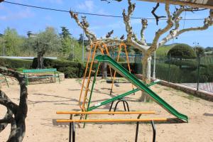 un parque infantil con un tobogán verde en Ca La Maria, en Tordera