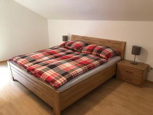 ein Schlafzimmer mit einem Bett mit einer karierten Decke und einem Nachttisch in der Unterkunft Kienburg in Matrei in Osttirol