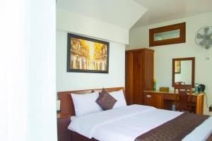 a bedroom with a bed and a desk with a mirror at Duy Thảo Hotel in Da Lat