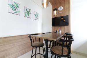 - une salle à manger avec une table et des tabourets en bois dans l'établissement Oliver's Guest House, à Tangerang