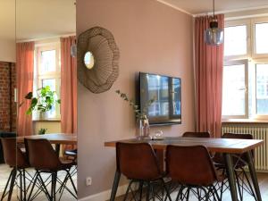comedor con mesa, sillas y espejo en Apartament stare miasto, en Gdansk