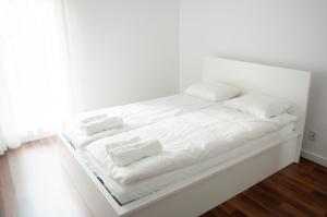 a white bed with white sheets and pillows on it at Apartament Verde in Łódź