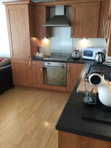 a kitchen with wooden cabinets and a counter top at Riverheights very near SSE Hydro in Glasgow