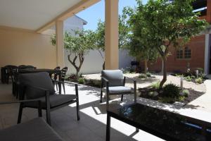 a patio with a table and chairs and trees at casa Agrifoglio in Terralba