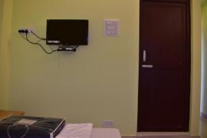 a room with a door and a television on the wall at Malakar Home stay in Port Blair