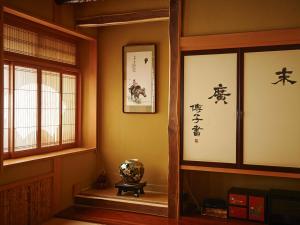
a room with a clock on the wall and a painting on the wall at Irorinoyado Ashina in Aizuwakamatsu
