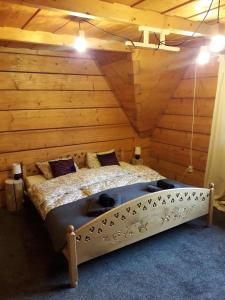 una camera con un letto in una stanza con pareti in legno di Apartament Zakątek Góralki a Zakopane